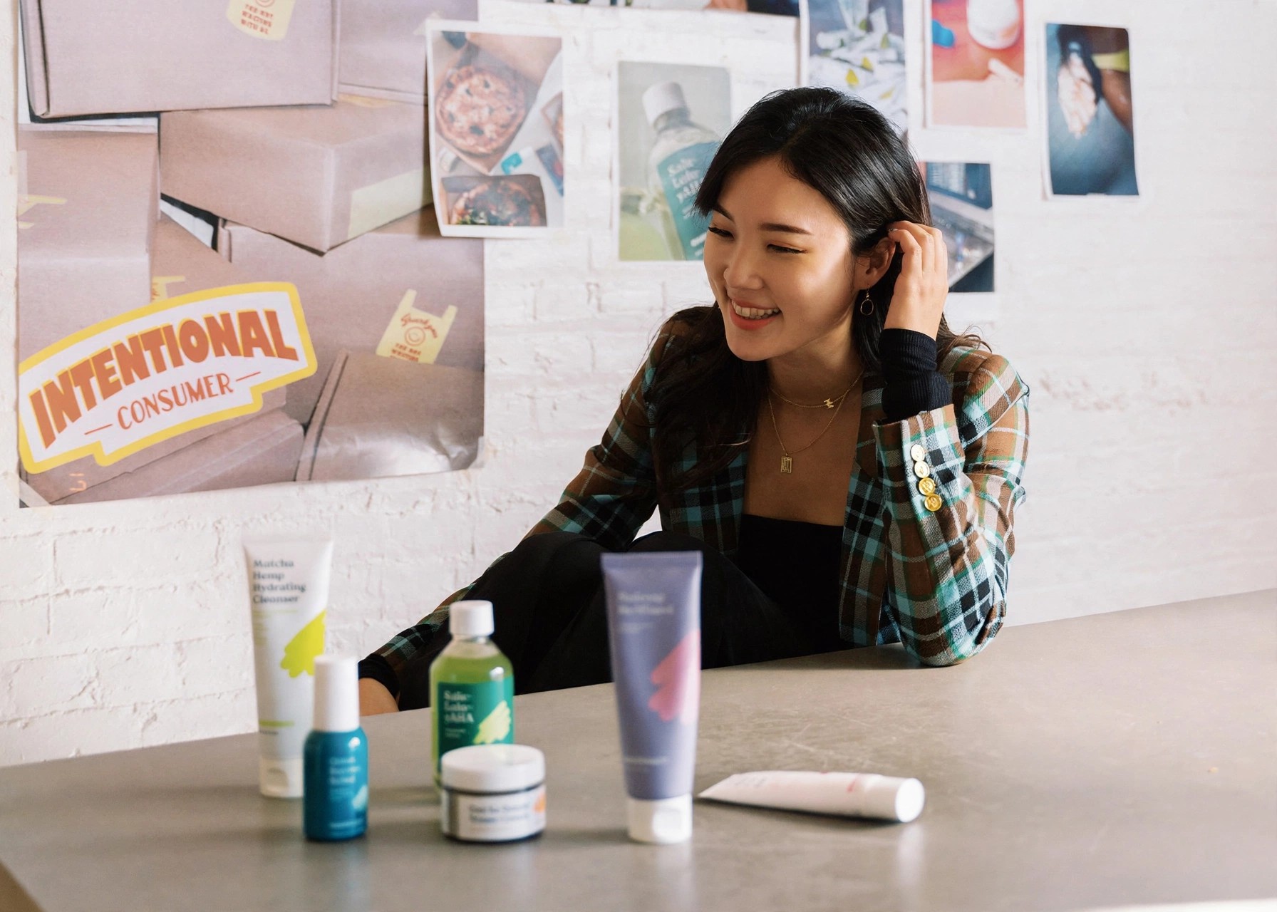 Liah Yoo laughs while sitting with KraveBeauty products displayed.
