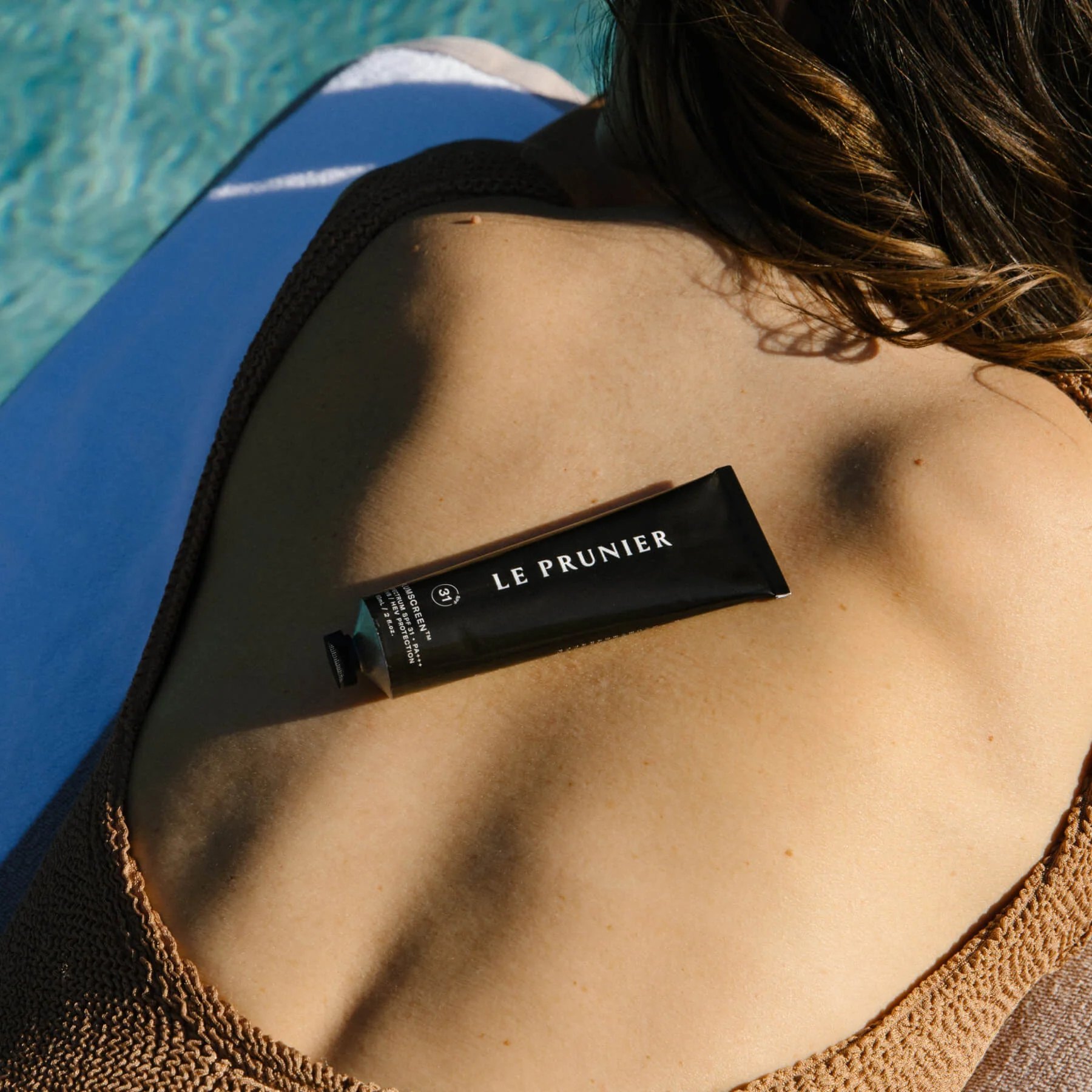 Overhead view of Plumscreen on skin by the pool.