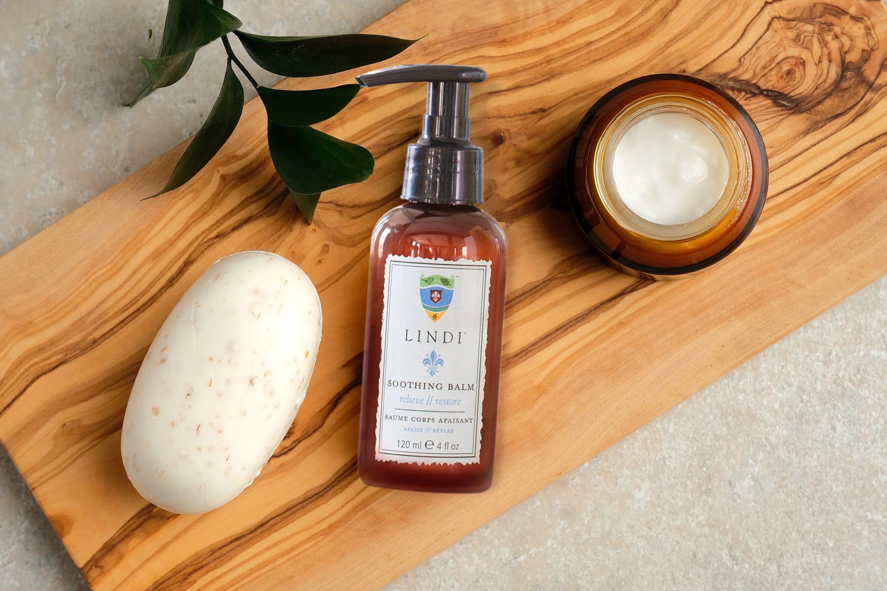 Soothing Balm bottle and cream jar arranged on wooden board.