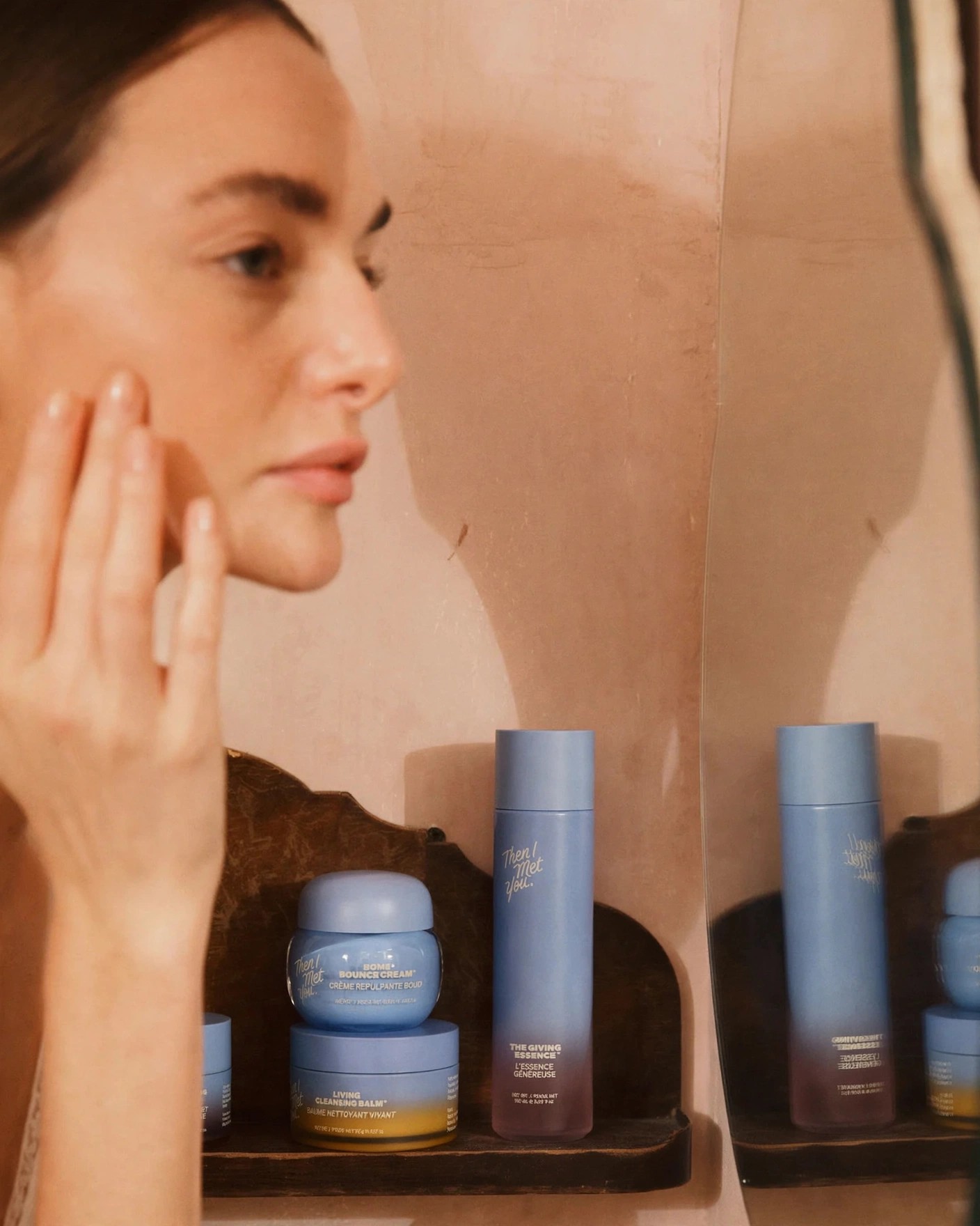 Profile view of woman with skincare jars on wooden shelf.