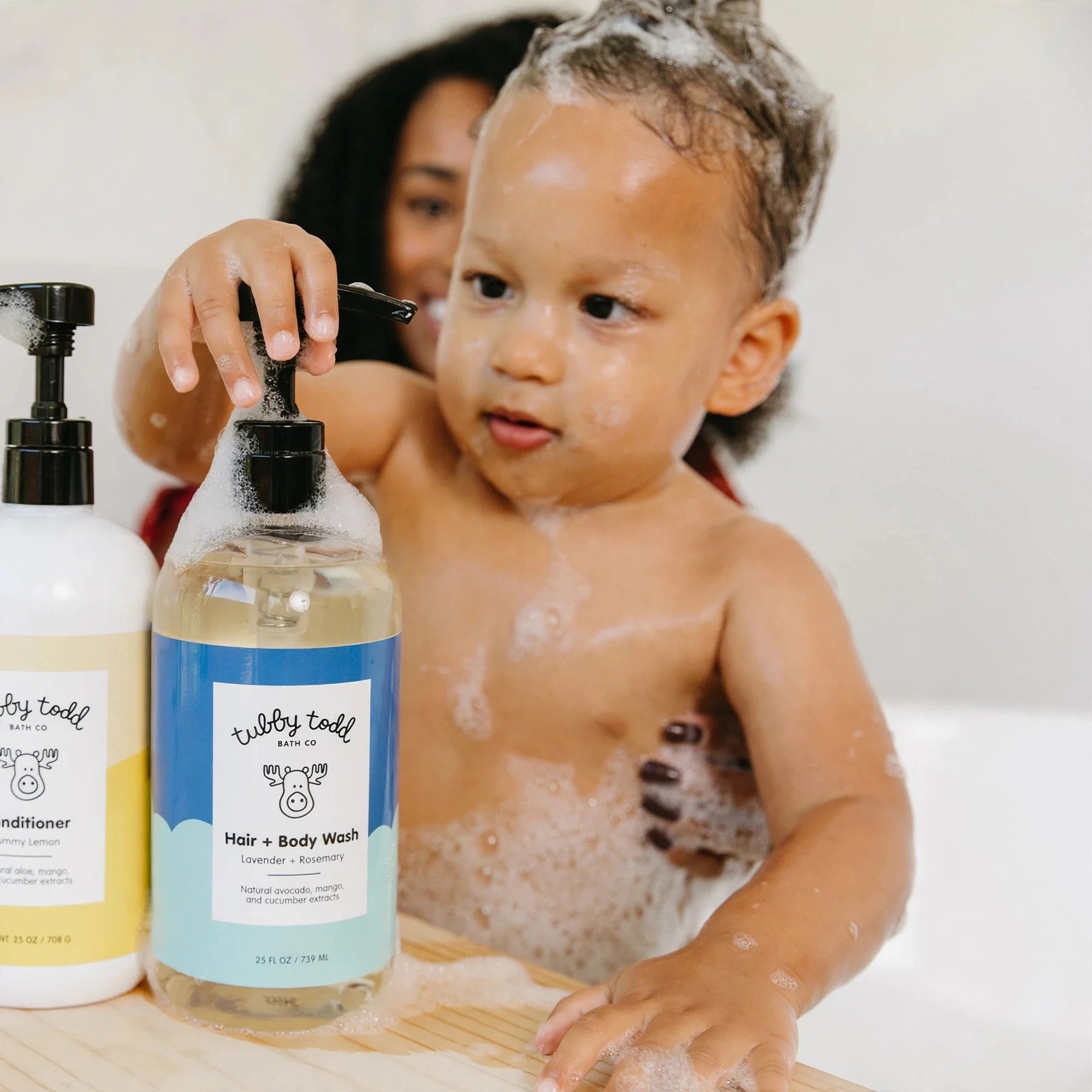 Child covered in suds beside Tubby Todd wash bottles.